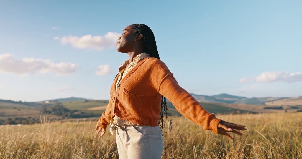Happy, field and black woman with peace, sunshine and vacation with nature, fresh air and journey.